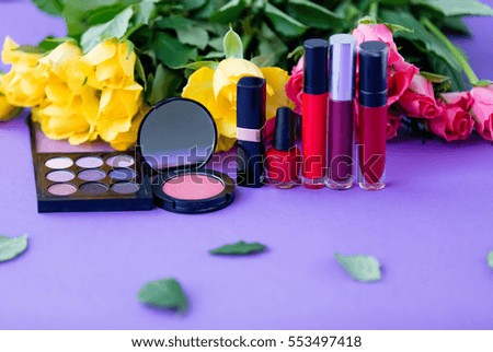 beautiful yellow and pink rose flowers and makeup cosmetics close-up on purple background