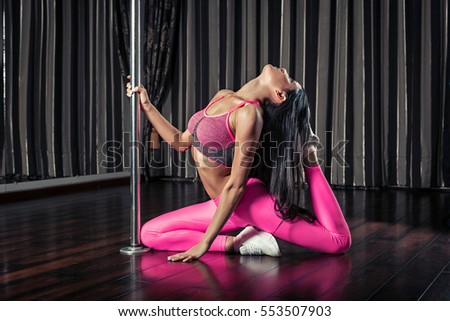 Young gymnast slim pole dancer sitting in fitness wear
