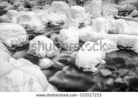 Long exposure. River in winter forest. Jalovecka valley in Slovakia. Black and white photography