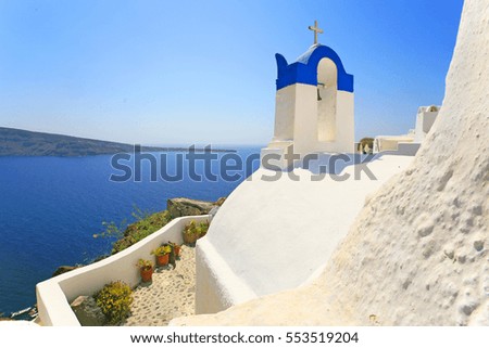 white walls and blue bell tower of a church overlooking the caldera in Santorini island, Greece