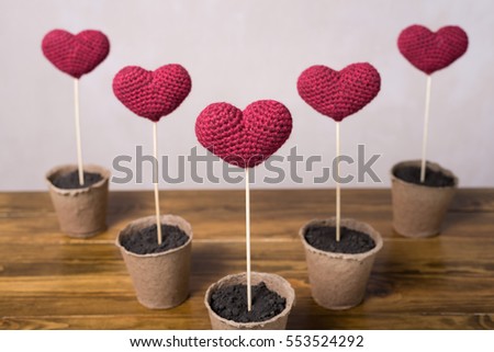Five crocheted hearts in peat glasses