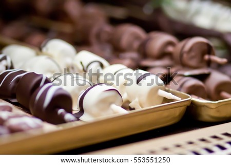 Many chocolates handmade in the window of a candy store. Multi-colored chocolate products, beautiful and delicious.