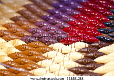 Many chocolates handmade in the window of a candy store. Multi-colored chocolate products, beautiful and delicious.