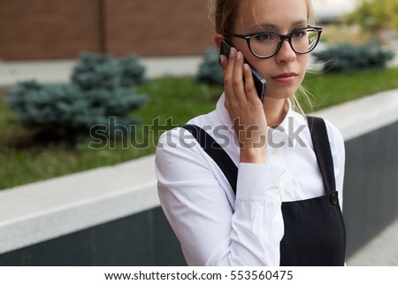 Young business woman talking by mobile phone outdoors.