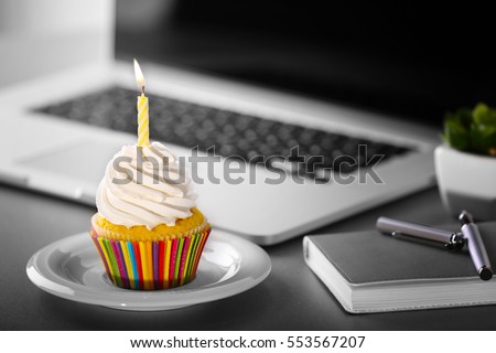 Tasty cupcake on working place Royalty-Free Stock Photo #553567207