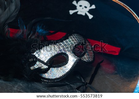 Venetian mask with black feathers, a pirate hat with Golden braid, Mardi Gras