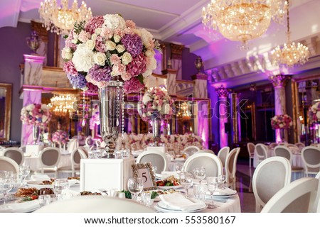 Table number 5 decorated with pink and violet hydrangeas and served with sparkling glassware Royalty-Free Stock Photo #553580167