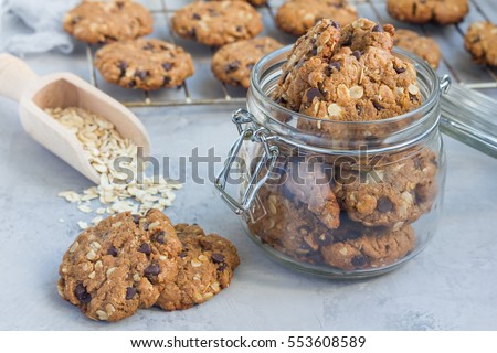 Flourless gluten free peanut butter, oatmeal and chocolate chips cookies in glass jar and on table, horizontal Royalty-Free Stock Photo #553608589
