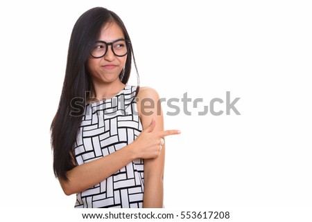 Young Asian teenage nerd girl pointing finger while looking disgusted isolated against white background