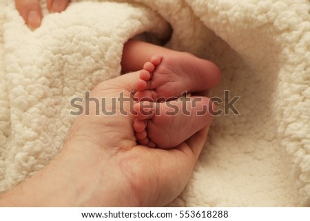   Sweet baby feet in a loving hand
