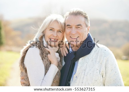 Portrait of cheerful senior couple enjoying day in countryside