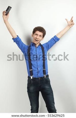 Happy Guy in a blue shirt with a phone on a white background