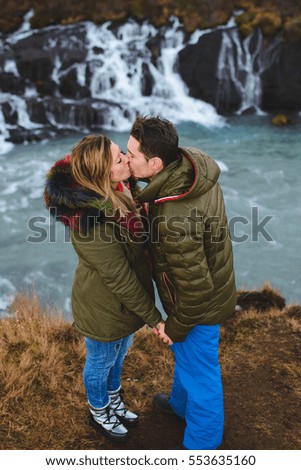 couple kissing on hill at waterfall in Iceland