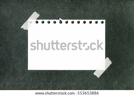 notebook paper sheets with sticky tape stuck on dark green background paper texture
