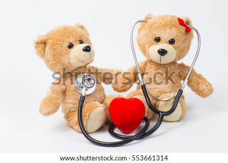 Close up Plush Teddy Bear with Stethoscope Device on Top of a Glass Table, Emphasizing Copy Space.
