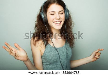 lifestyle and people concept: young woman with headphones listening music. 