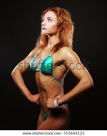 blond bodybuilder woman in bikin on black background