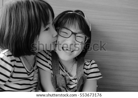 Cute little asian girl having fun in home, sisters hugging and laughing,  Color tone black and white