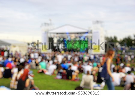 A crowd of people at a concert in the park. Near the scene. Blurred background Royalty-Free Stock Photo #553690315