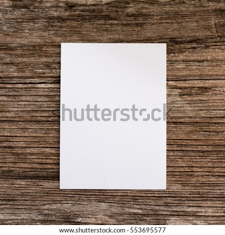 Paper note white on wooden background.