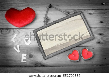 empty wooden signboard next heart sign candle in glass and red heart over old wood, vintage background ready to put photographs or text.