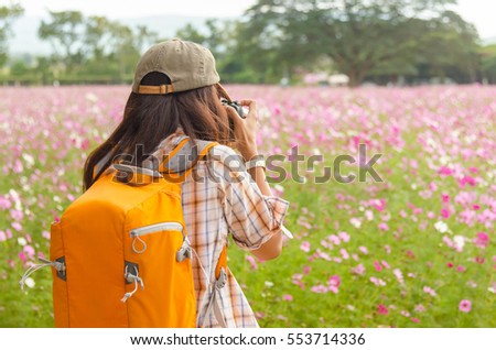 The young woman nature photographer taking pictures in the garden