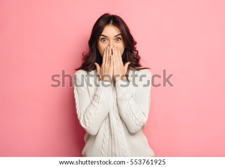 Portrait of amazed young woman over pink background Royalty-Free Stock Photo #553761925
