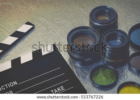Clapperboard, lenses and filters on the table