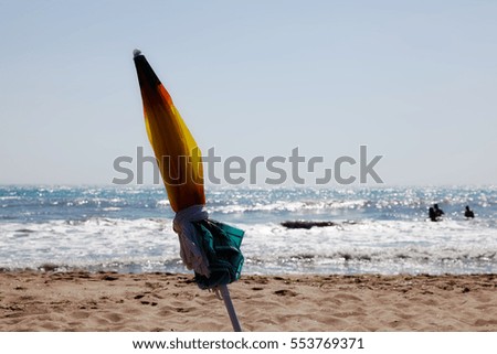 Folded parasol on the beach