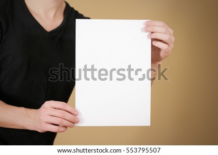 Man in black t shirt holding blank white A4 paper. Leaflet presentation. Pamphlet hold hands. Man show clear offset paper. Sheet template.