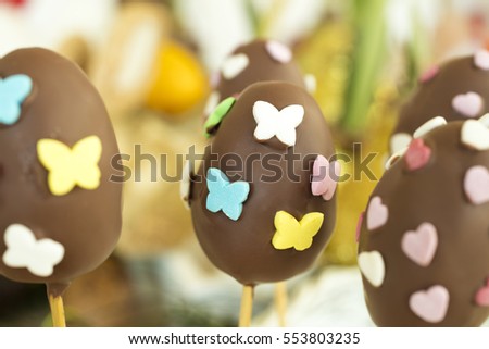 Detail of chocolate Easter eggs with heart and butterfly shaped candies.