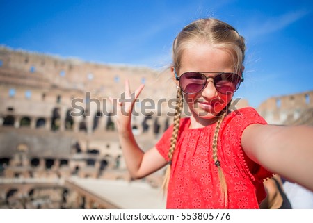 Little girl making selfie in Coliseum, Rome, Italy. Kid portrait at famous places in Europe
