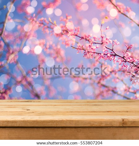 Empty wooden deck table over blurred bokeh spring garden background for product montage display