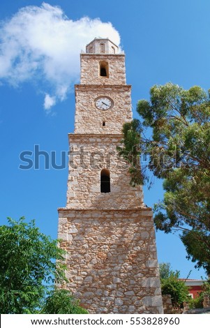 The old stone clock tower at Emborio on the Greek island of Halki. Broken for many years, the clock is always at twenty past four. Royalty-Free Stock Photo #553828960
