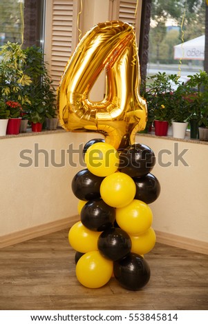 Birthday party for child four years old. Yellow and black balloons in a room. Stylish Birthday decorations