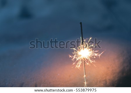 sparkler in the snow in the evening