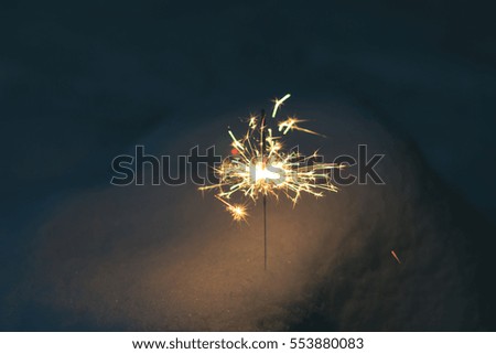 sparkler in the snow in the evening