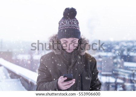 young man in winter on a city street on a frosty day