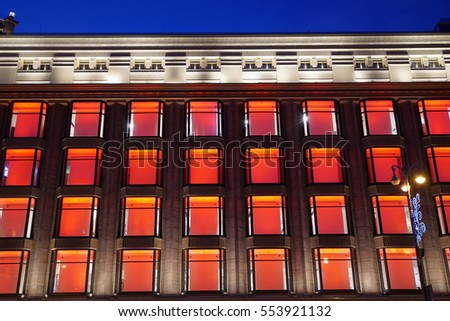 Multicolor facade of Kiev Central Department store (TSUM) at the night. Color illuminated decorative windows on sky background. Architecture details. Colors: orange, red