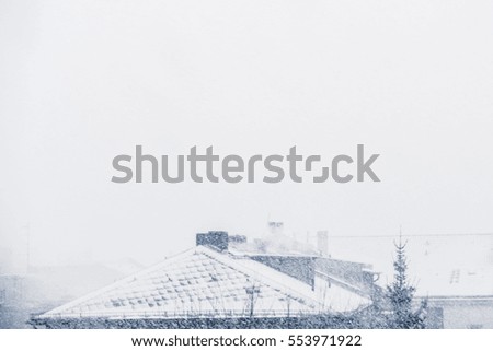snow cityscape / rooftops during winter snowing 