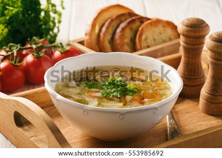 Vegetable soup with bread on wooden tray.  Royalty-Free Stock Photo #553985692