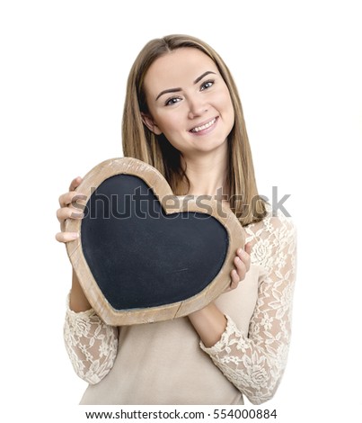 Boards to write with chalk made of wood in the shape of a heart in the hands of a young girl