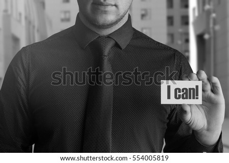 Male businessman in a shirt and tie is holding a business card with the text I can