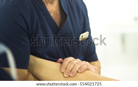 Surgeon in hospital surgery in sterile uniform "scrubs" in operating theater emergency room in knee mobility operation.