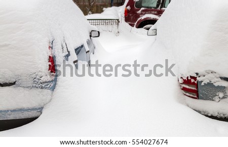 Car covered with snow in the parking after a snow storm