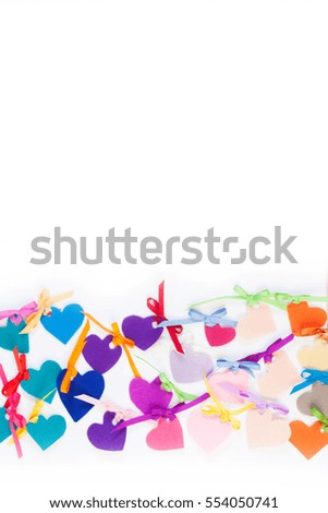 Bright colored hearts made of felt. White background.