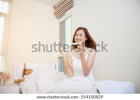 Beautiful young finding out results of a pregnancy test. asian white models - in love, relationship, dating, happy lovers, concept shot, against grey background.