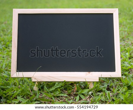 mini blackboard isolated on grass field background
