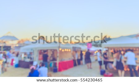 abstract blur image of food stall at day festival for background usage . (vintage tone)