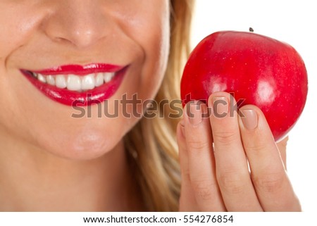 Close up picture of a beautiful woman's red lips and a fresh red apple
